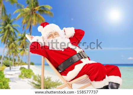 Relaxed Santa Claus sitting on a chair, on a tropical beach, enjoying the sun