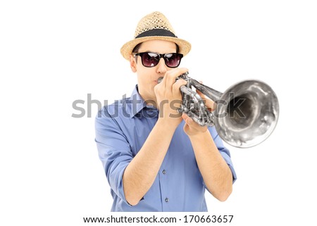Young male musician with sunglasses blowing into trumpet, isolated on white background