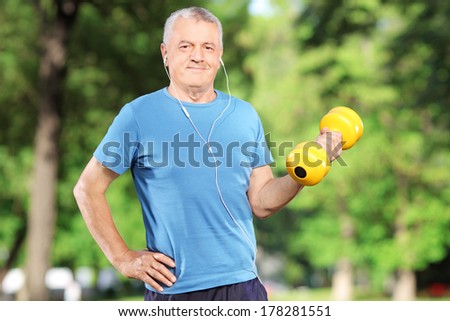Senior man exercising with weight in a park