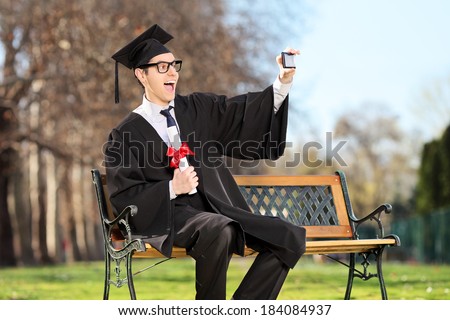 Excited college student taking a selfie in park