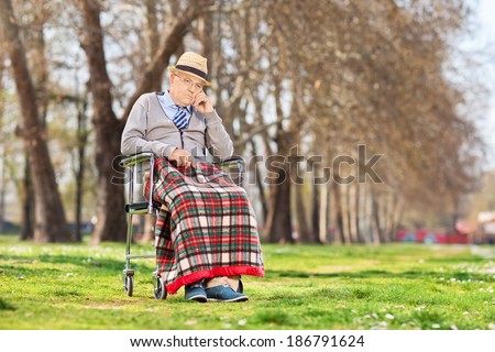 Grumpy old man sitting in a wheelchair outdoors
