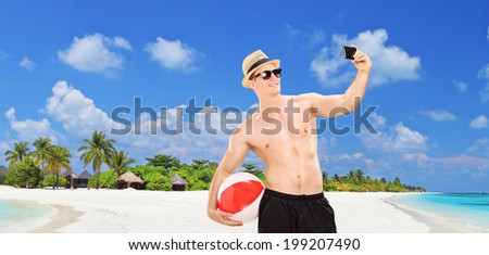 Panoramic view of a handsome man taking a selfie on a tropical beach at Maldives islands