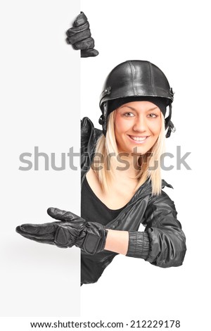 Female biker pointing on a panel with her hand isolated on white background