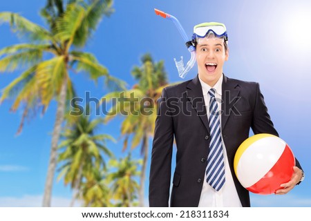 Man standing on beach with snorkel and beach ball