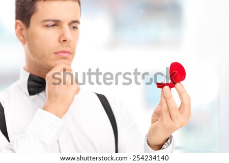 Young man choosing an engagement ring in a jewelry store