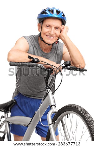Vertical shot of a senior in sportswear leaning on a bicycle and posing isolated on white background