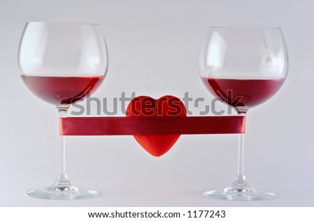 Two wine glasses wrapped with tape and heart against white background