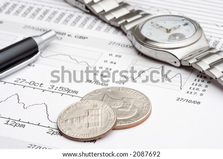 A close up of financial charts, some change and an expensive watch