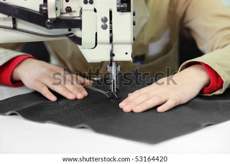 Tailor working on a sewing machine at textile factory
