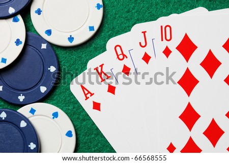 Royal straight flush poker cards with gambling chips on a green felt table background