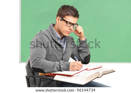 Young male in thoughts doing an exam isolated on white background