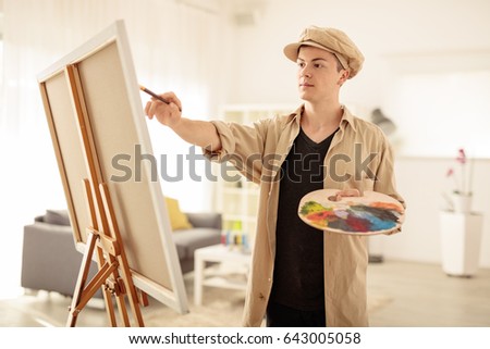 Teenage painter painting on a canvas in an art studio