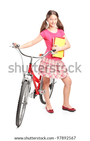 Full length portrait a girl holding a notebooks and a bike isolated on white background