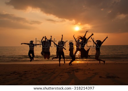 Silhouette photo of the team celebration on the beach at sunset