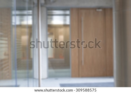 De-focused office environment with glass partitions and wood doors