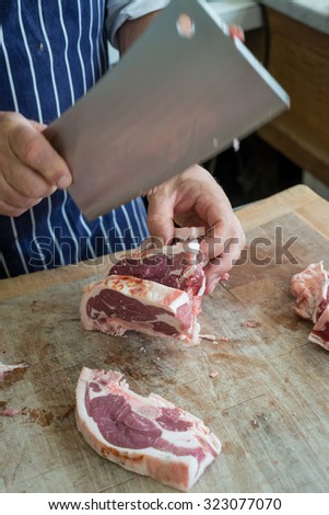 Friendly man preparing raw meat at the butchers