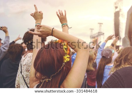 Crowd at an outdoor music festival with outstretched arms
