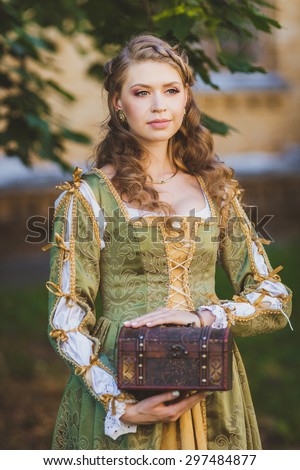 Beautiful girl in historical green dress with little chest