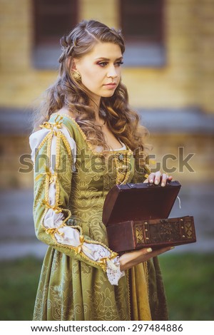 Beautiful girl in historical green dress with little chest
