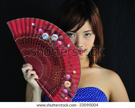 Very seductive young asian woman with a red fan