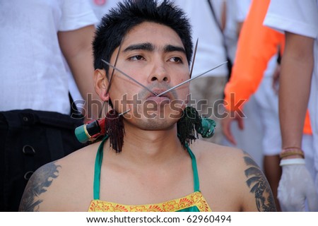 PHUKET, THAILAND - OCTOBER 7 : the ninth lunar month of the Chinese calendar starts  the Vegetarian Festival October 7, 2010 in Phuket, Thailand. Participants in the festival perform acts of body piercing as a means of shifting evil spirits from individua