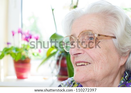 Happy old gray-haired woman with glasses