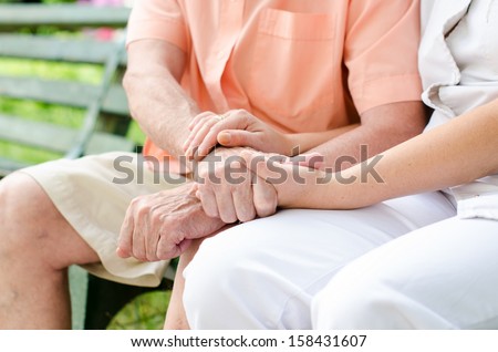 Young female hand holding an old man\'s hand.