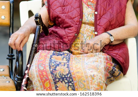 Hands of the old woman with a cane