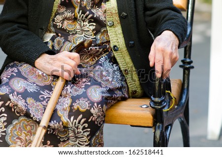 Hands of the senior woman with a cane