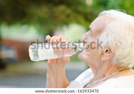 Closeup of elderly woman drinking water