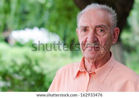 portrait of a cute old man at park