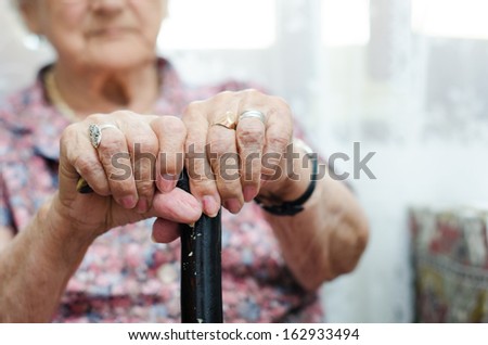 Two Hand Of Senior Woman Sitting In Chair Holding Walking Stick