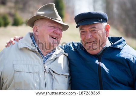 Two senior men laughing and talking