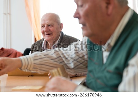 Elderly people playing rummy together