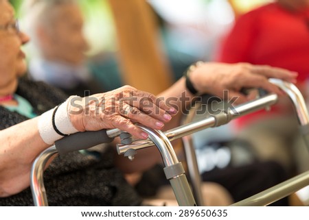 Old wrinkled women hand hold walker