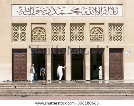 DUBAI, UNITED ARAB EMIRATES - JAN 26, 2014: Men at the entrance of Grand Mosque in the Bur District of Dubai, United Arab Emirates