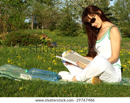 Beautiful woman reading happy a book in garden, green nature outdoor