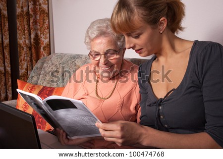 An old woman is a laptop explained by her granddaughter