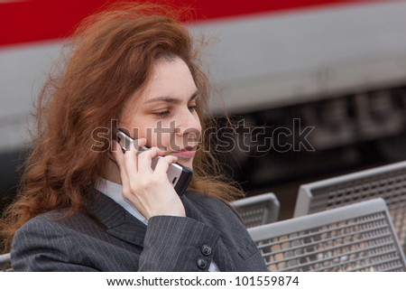 A young business woman is waiting for her train