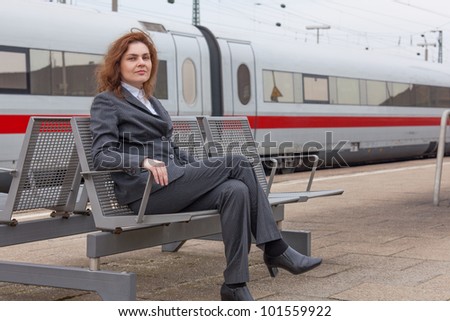 A young business woman is waiting for her train