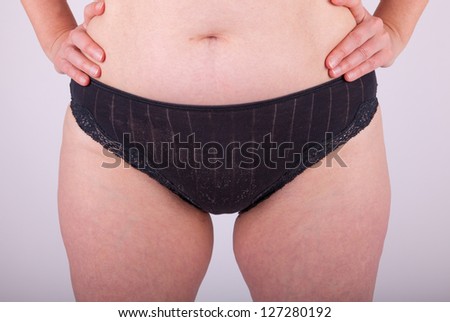 An elderly woman is in her underwear in front of the camera