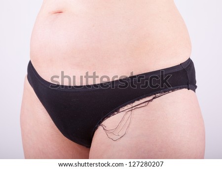 An elderly woman is in her underwear in front of the camera