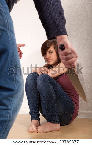 The angry father is threatening his daughter with a knife