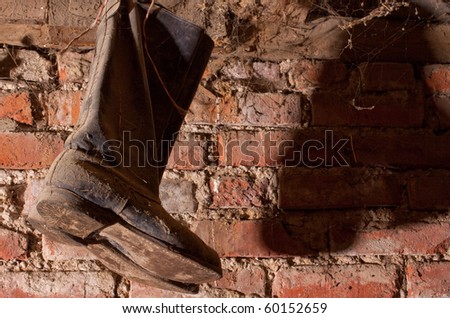 A pair of old boots hanging in the barn
