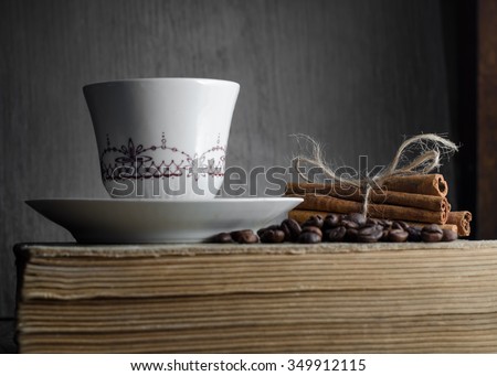 cup of coffee, cinnamon sticks on old books coffee beans on a wooden table. Free space for text. copy space