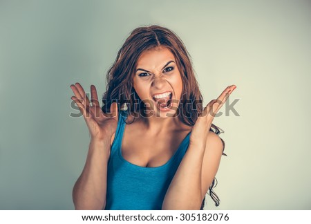 Close up very angry woman screaming in horror, grimace portrait. Stressed frustrated young lady having nervous breakdown isolated green background. Negative human emotion. long working hours concept