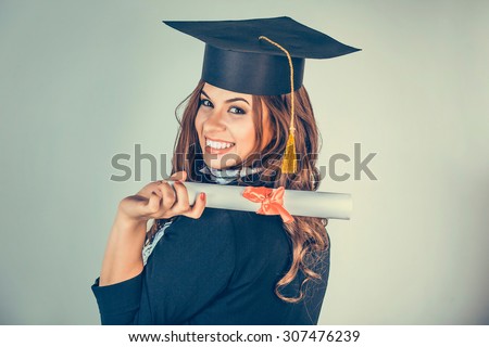 Portrait closeup beautiful happy latina graduate, graduated student girl, young woman in cap gown turning smiling holding diploma scroll isolated green background wall. Celebrating graduation ceremony