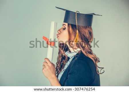 Portrait closeup beautiful happy glad latina graduate, graduated student girl young woman in cap gown turning kissing her diploma scroll isolated green background wall. Celebrating graduation ceremony