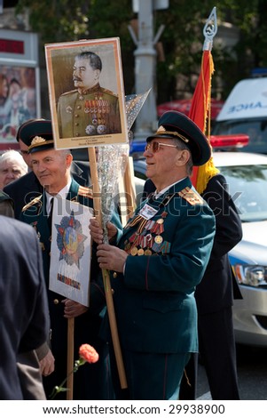 KIEV - MAY 9: Second world war veteran holding Stalin portrait while waiting for the beginning of Victory Day celebration parade May 9, 2009 in Kiev Ukraine