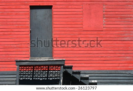 Wooden wall of old house with door, stairs and window